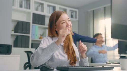 Une
jeune femme d'affaires caucasienne danse avec de la musique tout en travaillant au bureau.