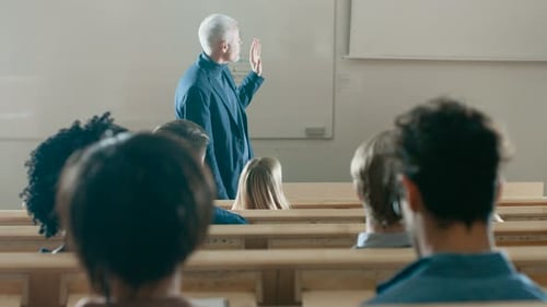 Vista posterior de los estudiantes en la sala de conferencias escuchando a un profesor prominente dando una conferencia. Br