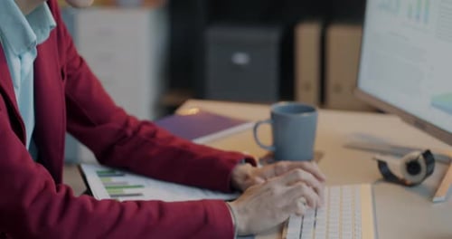 Office Worker Typing with Computer Using Wireless Keyboard Focused on Business Activity at Desk