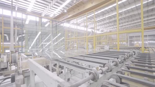 Industrial factory glass moves on the roller table. Automatic removal of flat glass from conveyor