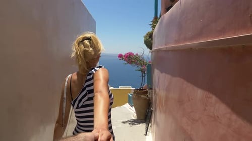 Follow me concept: POV male follows blond woman in blue, white dress