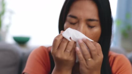 Young Woman Blowing Her Nose With a Tissue