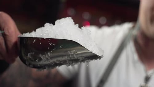 Slow Motion Closeup of Throwing Ice Into a Glass at the Bar