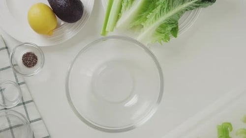 Céleri vert haché dans un bol en verre. Salade de laitue au céleri