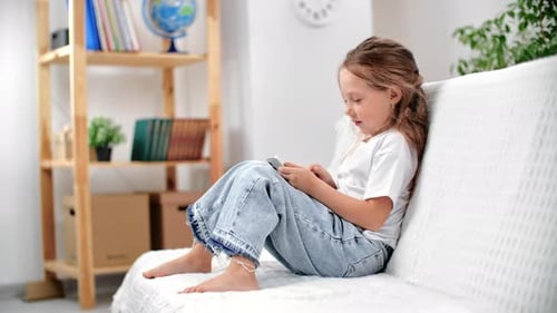 Girl with Smartphone Relaxing on Couch