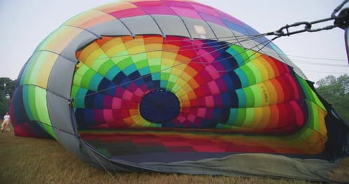 Slow motion close up of setting up of colorful hot air balloon before the flight.