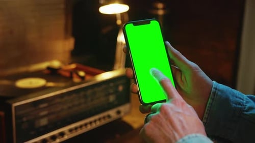 Close Up Shot of Hands Man Using Scrolling Mobile Phone with a Vertical Green Screen Indoors Social