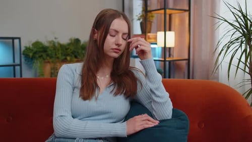 Thoughtful Woman Sitting Sadly on Couch