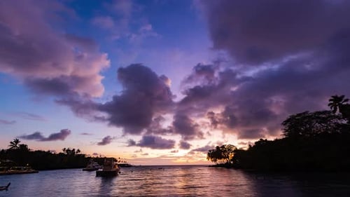 Timelapse - Beautiful sunset clouds over the ocean with sailboats in Hawaii