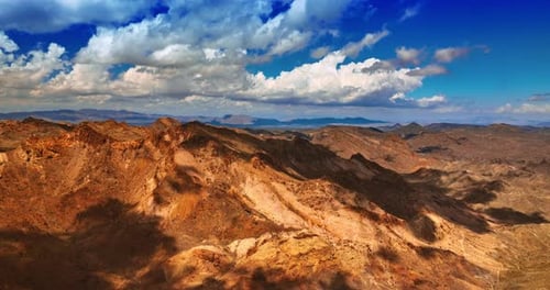 Beautiful fluffy clouds throw their shadows on the bare rocks. Scenic view of the mountains