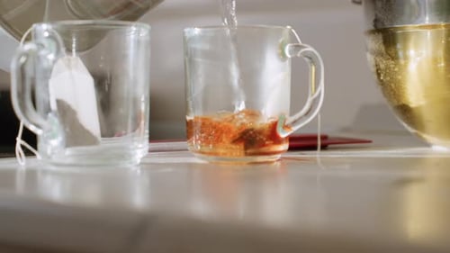 Pouring Hot Water Into Glass Cup With Teabag For Fresh Tea Preparation
