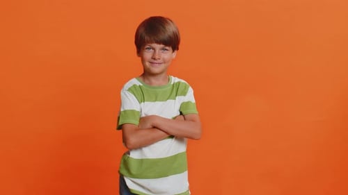 Smiling Boy With Crossed Arms on Orange Background