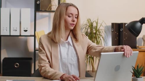 Young Business Woman Sitting at Office Workplace Desk Closing Laptop Pc After Finishing Remote Work