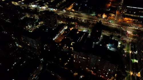 Aerial view of a residential neighborhood along a main avenue at night.