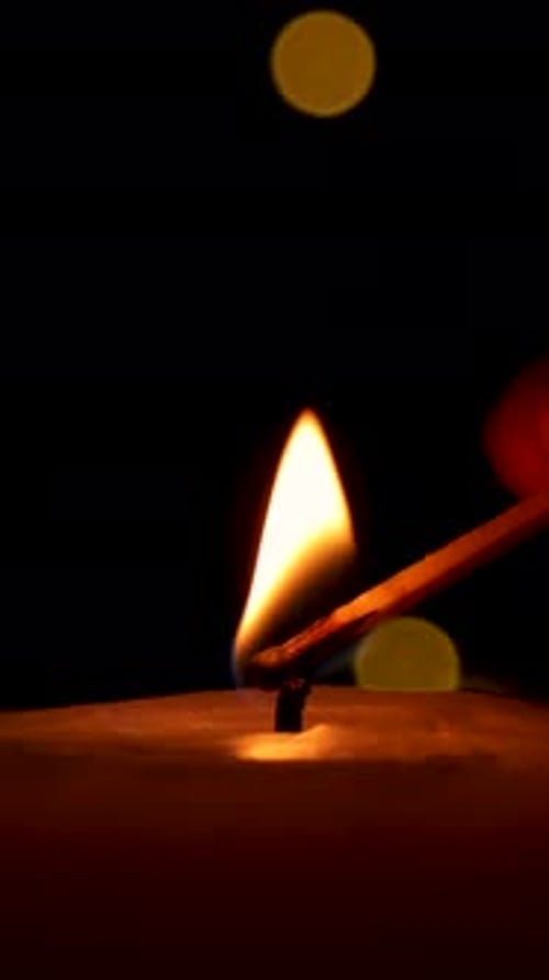 Candle Flame Ignites in the Darkness