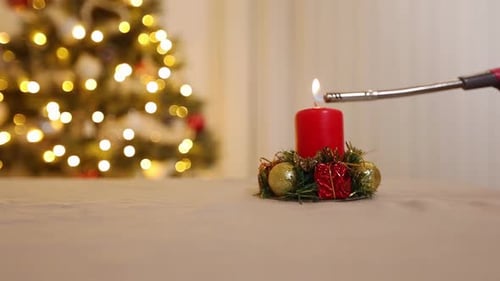 Lighting Christmas Candle with Tree in Background