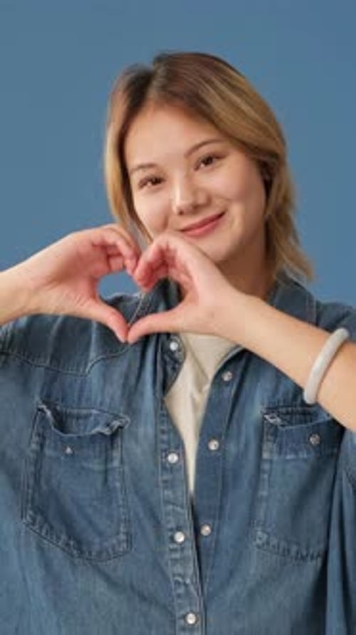 Woman Smiling, Forming Heart Shape with Hands