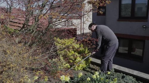 Homme âgé binant son jardin en profitant du soleil