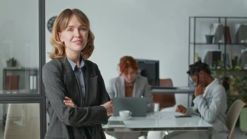 Confident Woman in Modern Office with Colleagues
