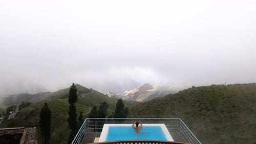 Piscina infinita en la cima de una montaña al aire libre contra un paisaje brumoso en Roque Nublo, Gran Canaria