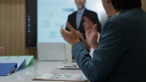 Professionals Applaud Presenter at Corporate Meeting