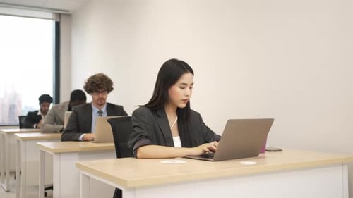 Focused Young Adults Working on Laptops in Modern Office