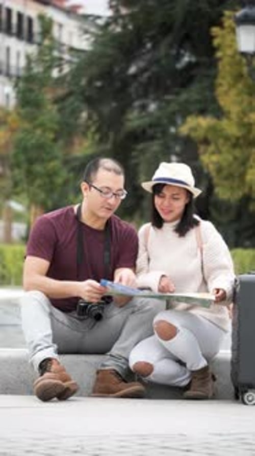 Couple Viewing a Map on Stairs in Urban Park