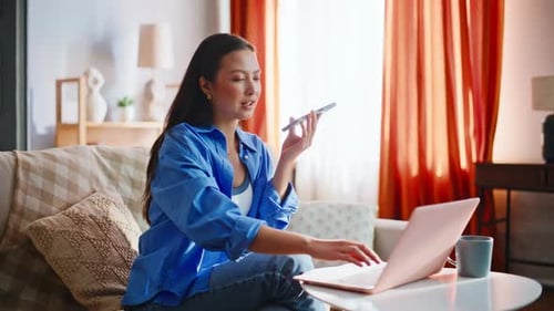 Young Asian Freelancer Gesturing Voice Call Home Sofa Pink Laptop Coffee Cup