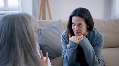 Distressed woman speaking with therapist in an office