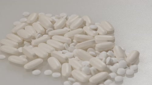 Close Dolly of various pills on a white surface