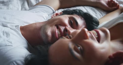 Slow motion close up of young couple is relaxing in the bedroom in the early morning in a sunny da