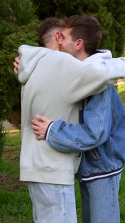 Young caucasian gay couple sharing intimate moments in park