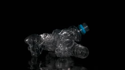 Crushed Plastic Bottle Rotating on Black Background