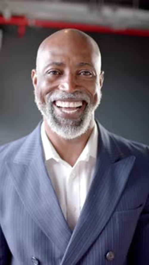 Vertical video of smiling african american businessman in office with copy space