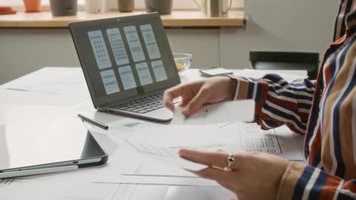 Woman Designs Mobile Application Interface at Desk