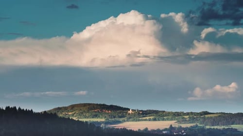 Dichte Wolken wirbeln und bilden sich am blauen Himmel über der ländlichen Landschaft. Ein Zeitraffervideo
.