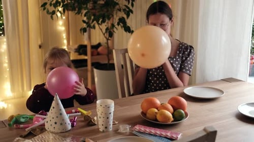 Children and Young Woman Blow Up Birthday Balloons