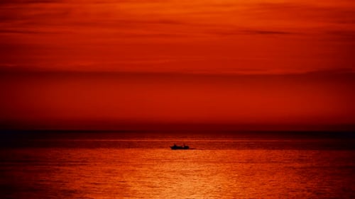 Bateau de pêche en mer au lever du soleil