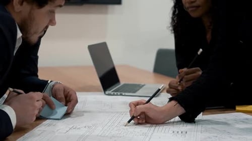 Team Collaborates on Blueprint in Modern Office Setting