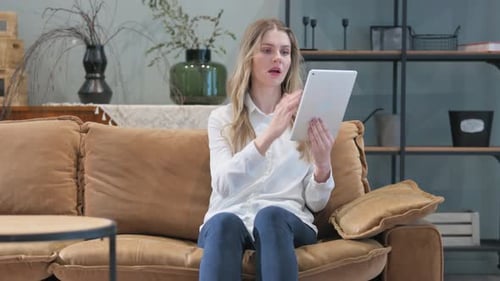 Frustrated Woman Using Tablet for Video Call at Home