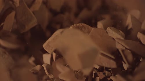 Top View of Raw Chocolate Chunks with Powdered Chocolate Flying in Super Slow Motion Pieces of