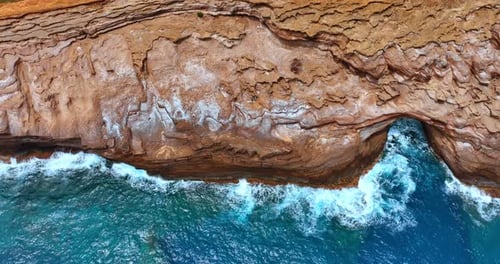 Vuela por las rocas desnudas curvadas por el poder del agua. Paisaje acuático azul que choca contra los acantilados
.