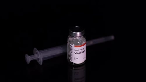 Vaccine vial and syringe on black background