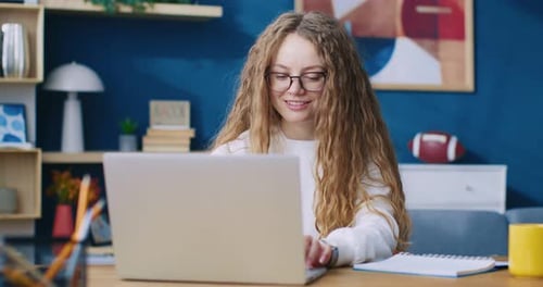 Woman Opens Laptop and Types at Home Office