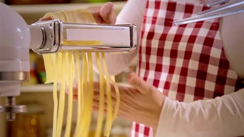 Woman Making Fresh Pasta with Machine in Kitchen