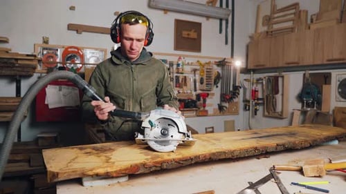 Man Using Circular Saw to Cut Wooden Plank