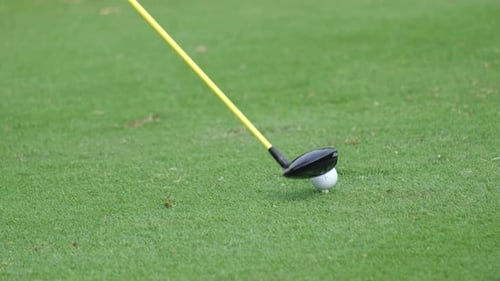 Slow motion close up professional golf player swinging golf club on the green. Golfer taking shot on