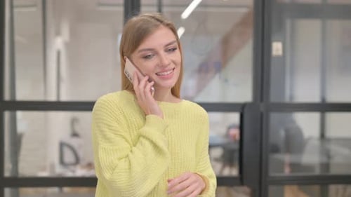 Young Woman Talking on Smartphone in Modern Office