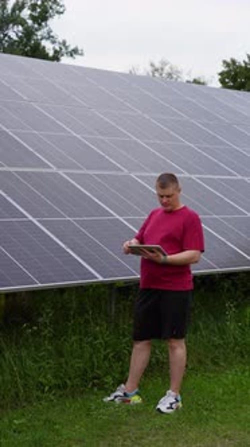 Nahaufnahme eines Technikers, der Sonnenkollektoren über ein Tablet-Gerät überwacht