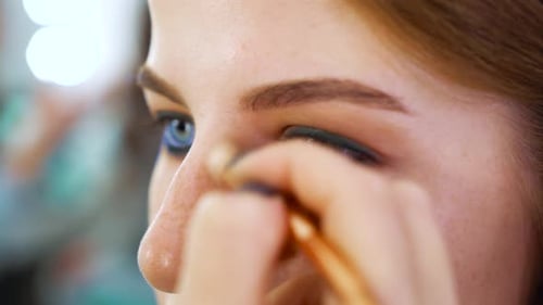 Young Woman Receiving Eyelid Makeup Application